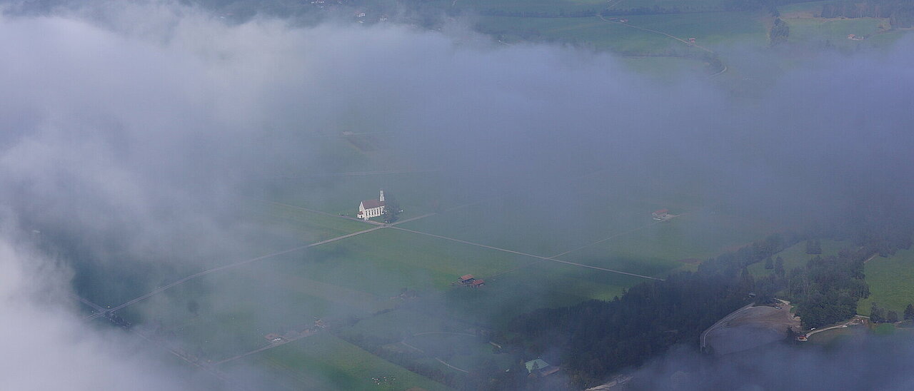 Our church St. Coloman in the Fog, Schwangau in the Background
