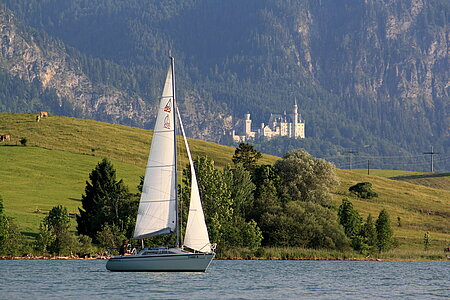 Sailingboat on lake Forggensee with Neuschwanstein castle in the background